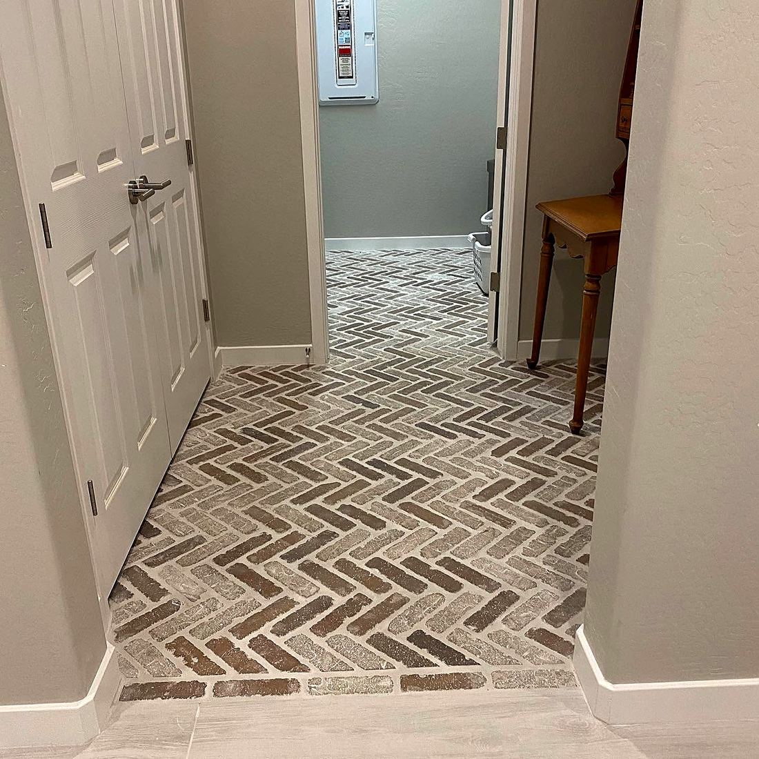 Brick-look tile laid in herringbone through a hallway