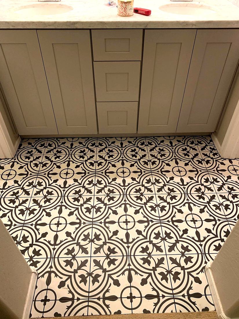 Black and white patterned tile bathroom floor in front of a vanity